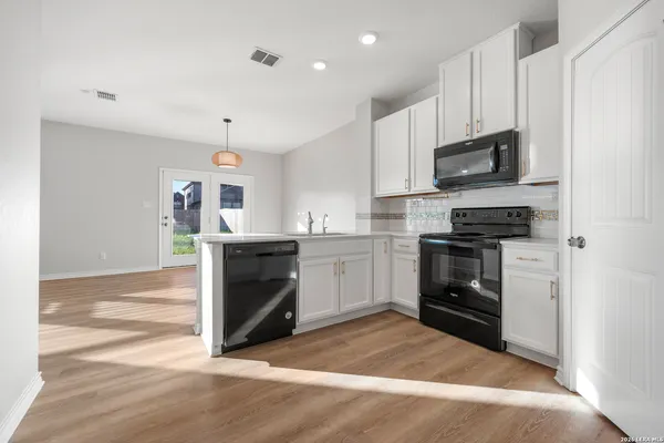 a kitchen with granite countertop a refrigerator stove and sink