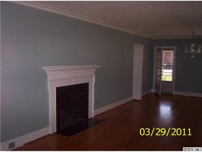 4710 Beatties Ford Road Charlotte, NC 28216 - Photo 5 of 6 a view of an empty room with wooden floor and a fireplace