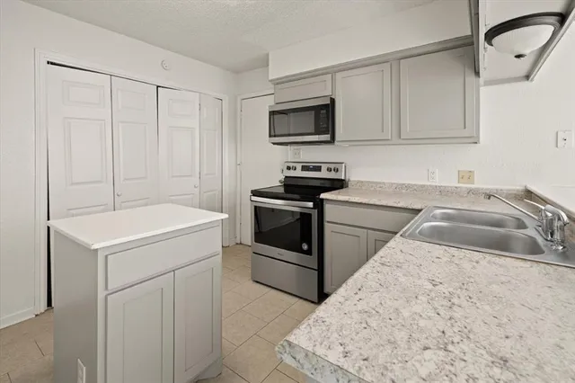 a kitchen with white cabinets sink and stainless steel appliances