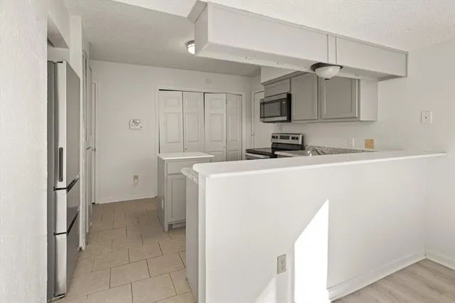 a kitchen with stainless steel appliances a refrigerator sink and microwave