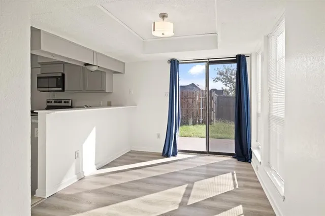 a view of a kitchen with a sink and dishwasher a refrigerator with wooden floor