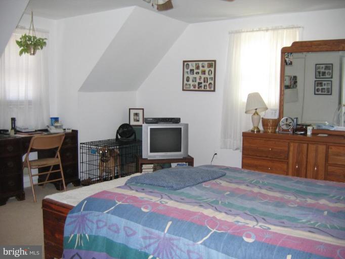 12712 Feldon Street Silver Spring, MD 20906 - Photo 4 of 12 a bedroom with a bed and a chair