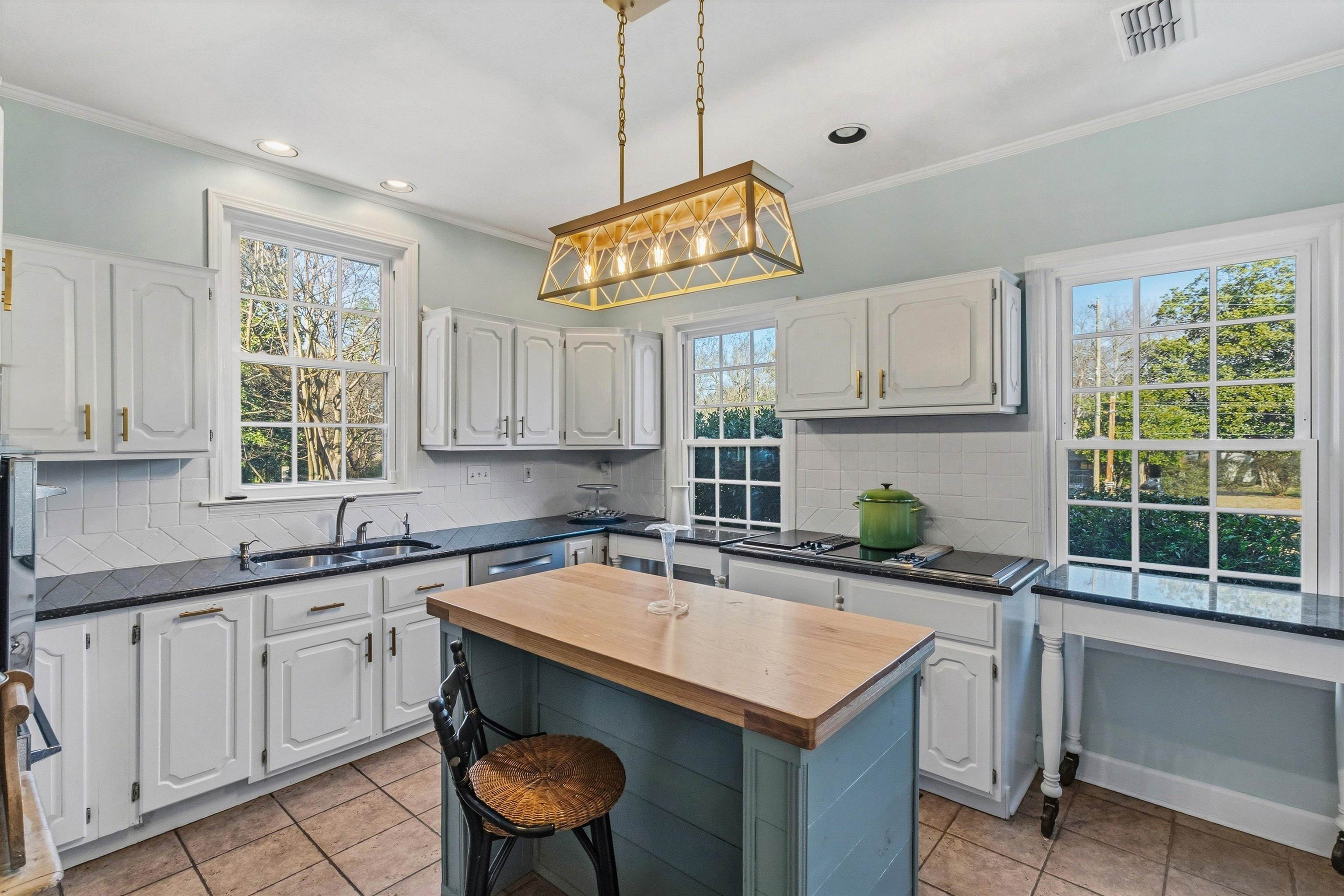 4009 Walnut Grove Road Memphis, TN 38117 - Photo 11 of 38 Kitchen featuring backsplash, wood counters, white cabinets, a kitchen island, and ornamental molding