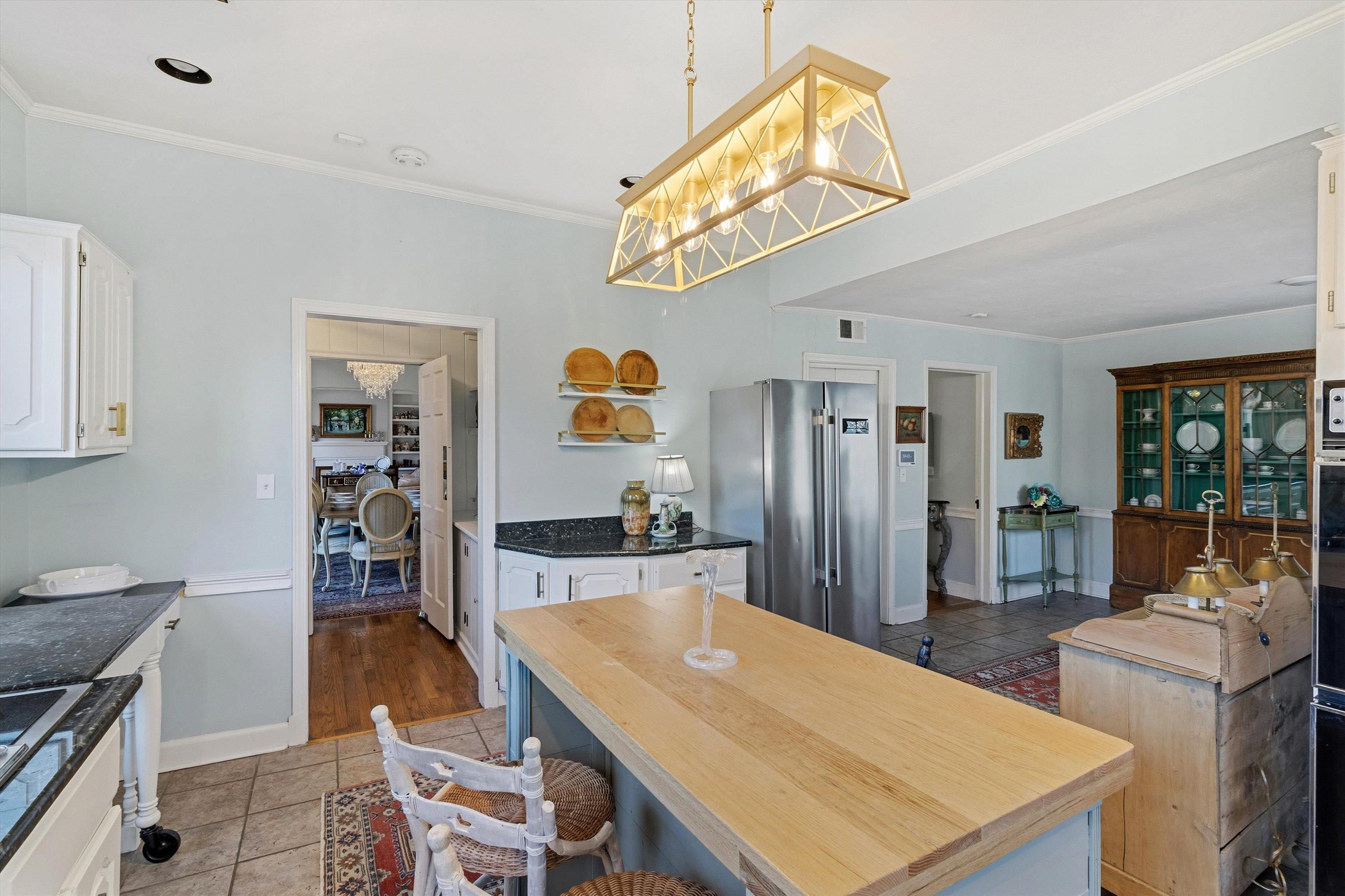 4009 Walnut Grove Road Memphis, TN 38117 - Photo 12 of 38 Kitchen with white cabinets, crown molding, freestanding refrigerator, decorative light fixtures, and light tile patterned flooring