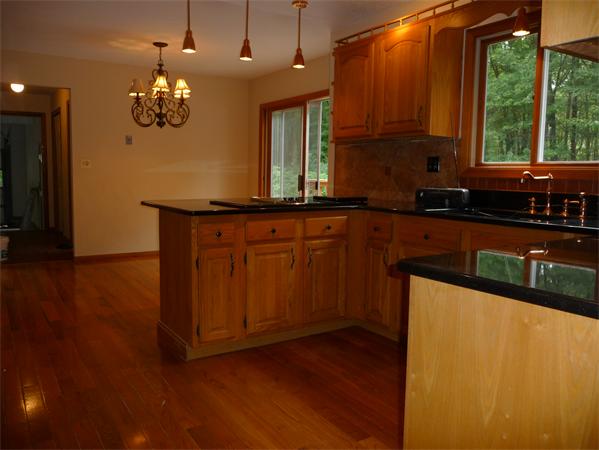 223 Three Rivers Road Wilbraham, MA 01095 - Photo 4 of 19 a kitchen with stainless steel appliances granite countertop wooden cabinets a stove a sink and a large window