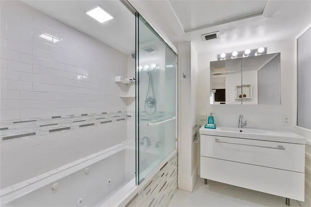 a bathroom with a bathtub sink and mirror
