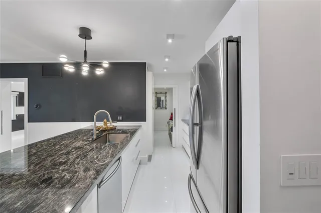 a kitchen with stainless steel appliances granite countertop a refrigerator and a sink