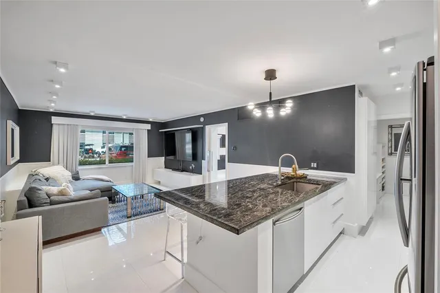 a kitchen with stainless steel appliances granite countertop a sink refrigerator and cabinets