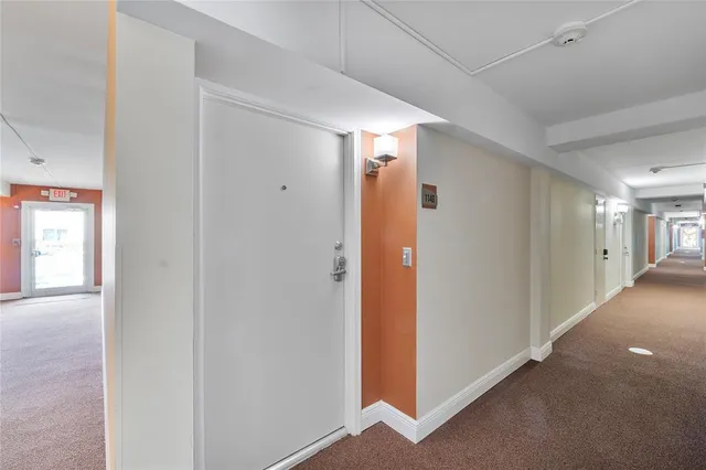 a tall yellow building with trees in front of it