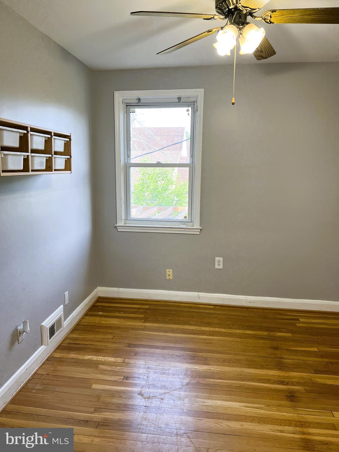 3705 Bancroft Road Baltimore, MD 21215 - Photo 27 of 50 a view of a room with window a ceiling fan and wooden floor