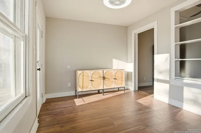 a view of a room with wooden floor windows and a fireplace