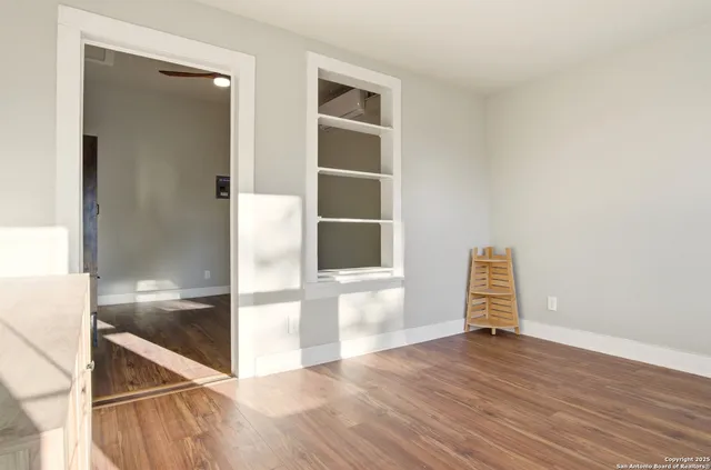 an empty room with wooden floor and door
