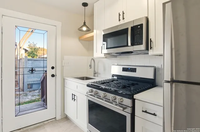 a kitchen with stainless steel appliances granite countertop a stove a microwave and a refrigerator