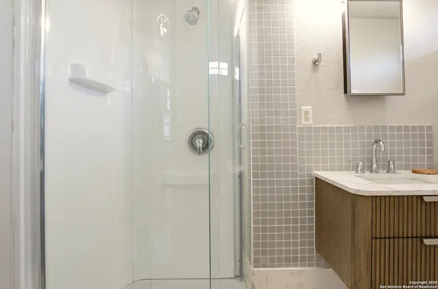 a bathroom with a sink a shower and a mirror