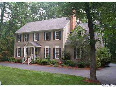 a front view of a house with a yard and green space