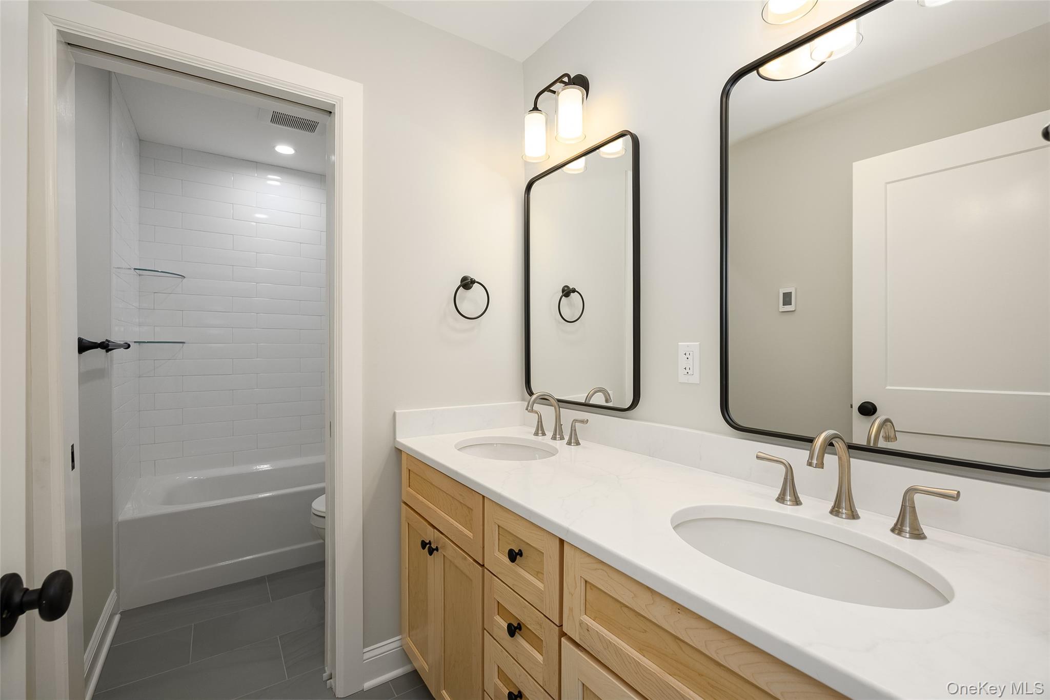 15 Henry Street, Unit 2 Beacon, NY 12508 - Photo 17 of 25 a bathroom with a granite countertop sink shower and a mirror