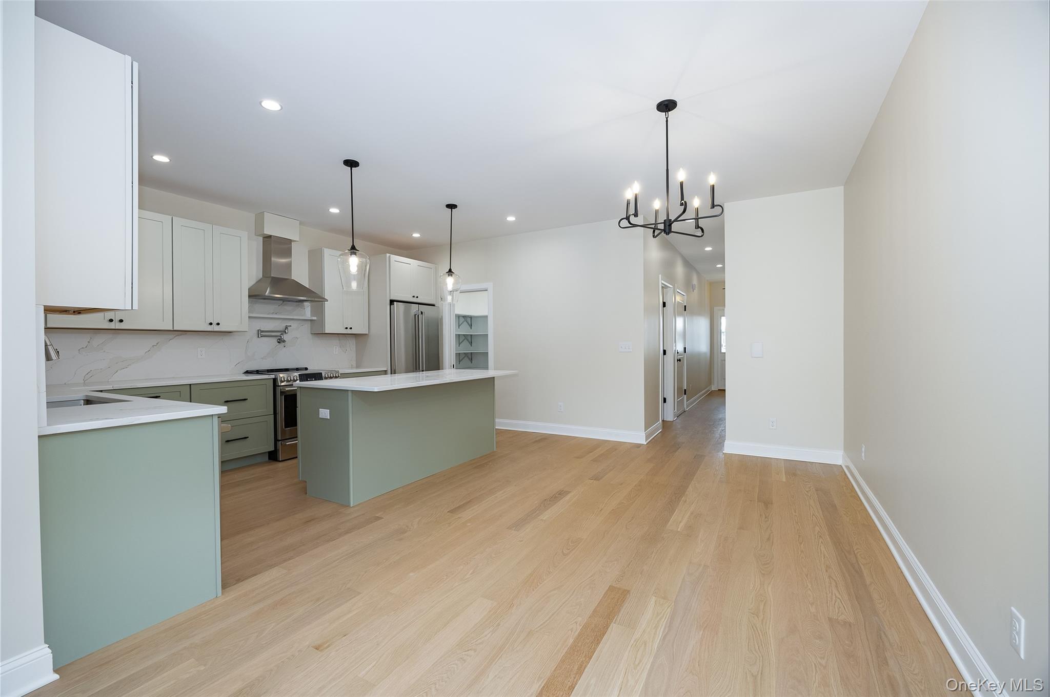 15 Henry Street, Unit 2 Beacon, NY 12508 - Photo 9 of 25 a kitchen with kitchen island white cabinets and stainless steel appliances