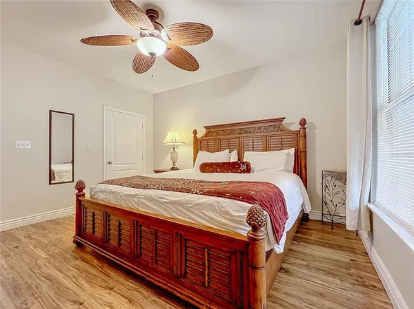 a bedroom with bed and wooden floor