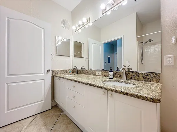 a bathroom with a granite countertop sink and a mirror