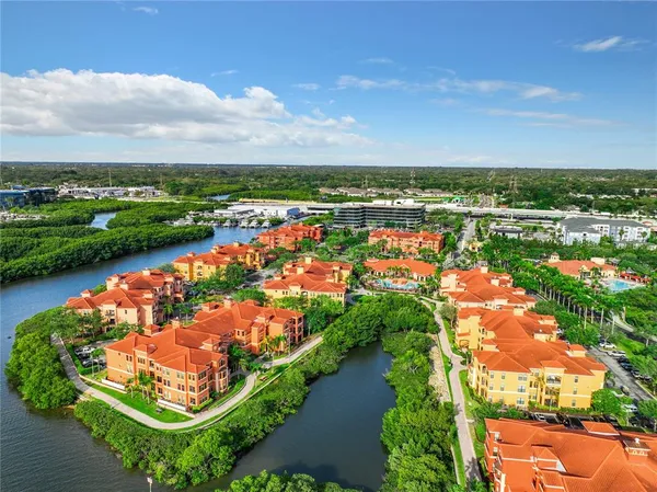 an aerial view of residential houses with outdoor space and lake view