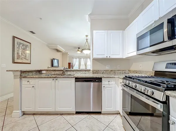 a kitchen with granite countertop a stove sink and cabinets