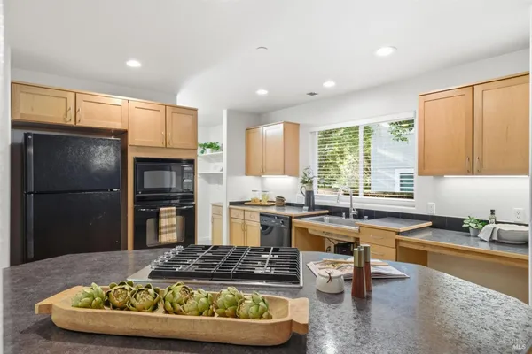 a kitchen with stainless steel appliances granite countertop a sink refrigerator and cabinets
