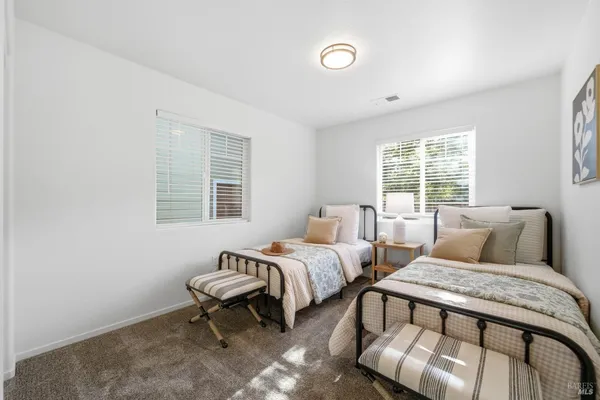 a bedroom with two beds and a window