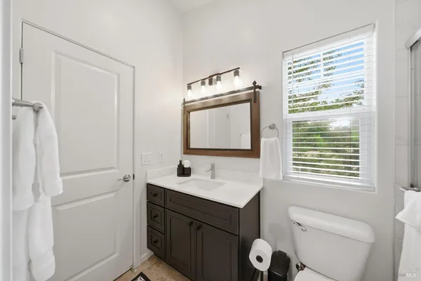a bathroom with a sink a toilet and a mirror
