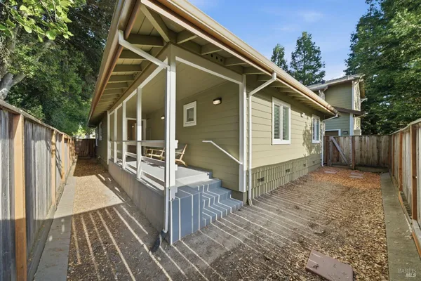 a view of wooden house with a small yard
