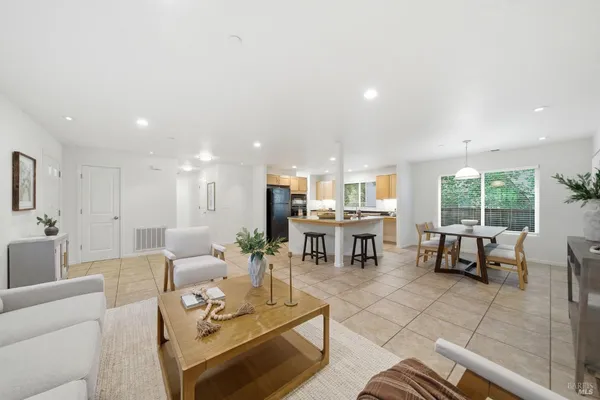 a living room with couches and kitchen view with kitchen view