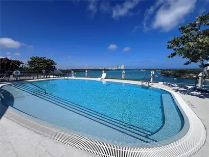 a view of swimming pool with outdoor seating and yard in the back