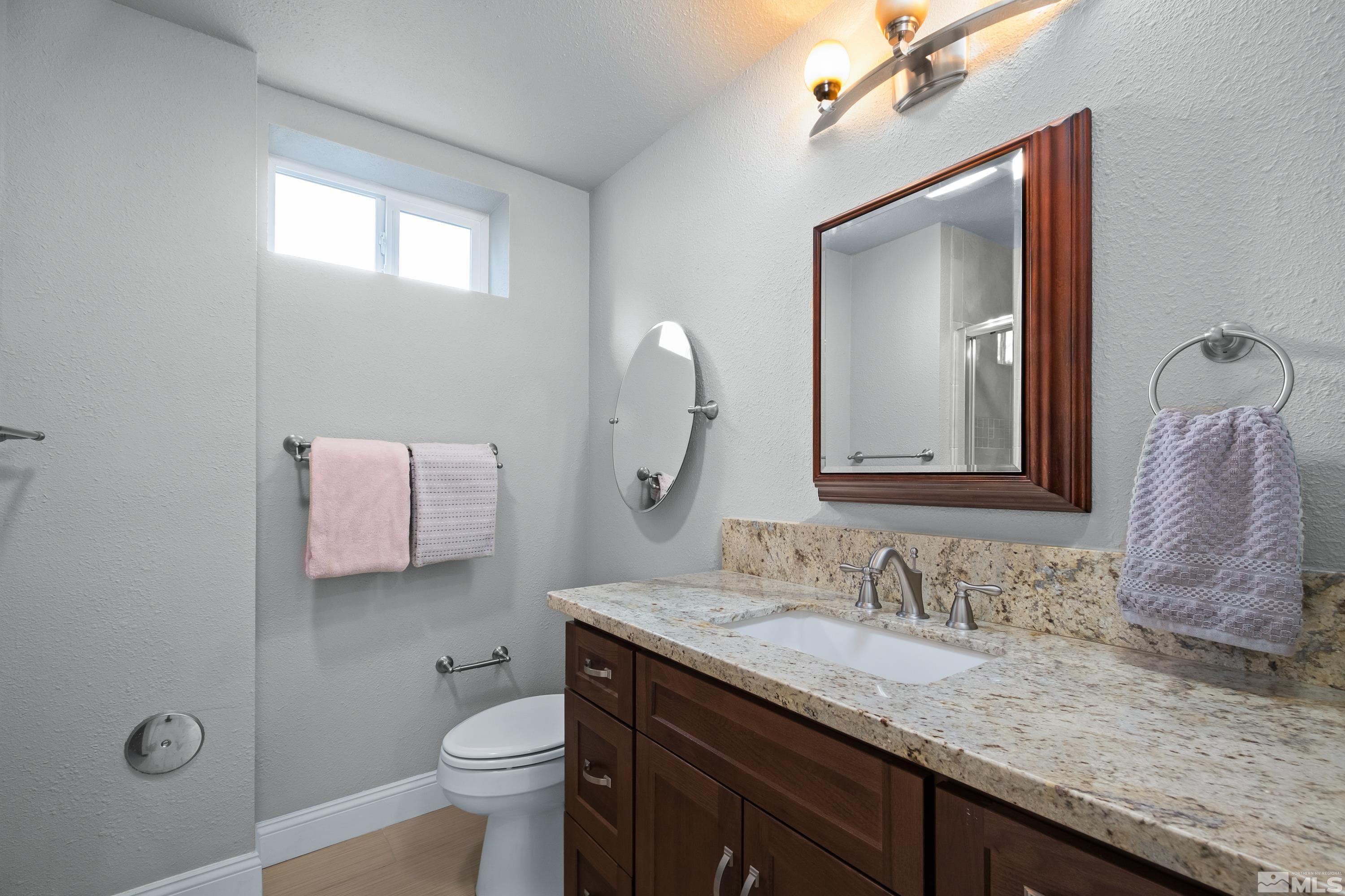 330 Chevy Chase Street Reno, NV 89509 - Photo 23 of 40 a bathroom with a granite countertop sink vanity mirror and toilet