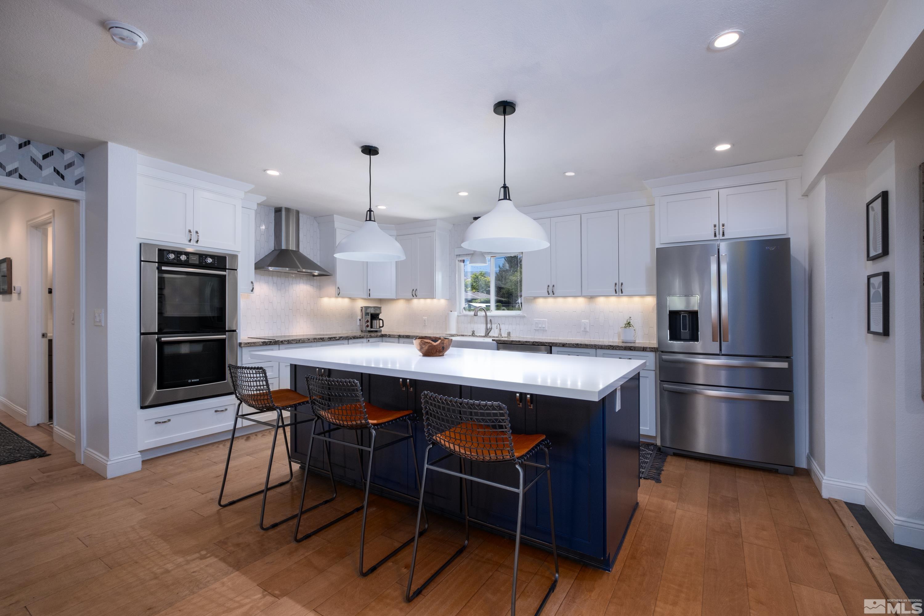 330 Chevy Chase Street Reno, NV 89509 - Photo 6 of 40 a kitchen with stainless steel appliances a dining table chairs refrigerator and microwave