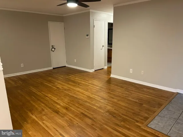 a view of an empty room with wooden floor