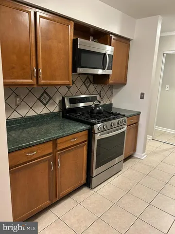 a kitchen with granite countertop cabinets stainless steel appliances and a counter space