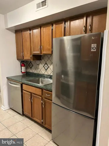 a kitchen with stainless steel appliances granite countertop a refrigerator and a stove