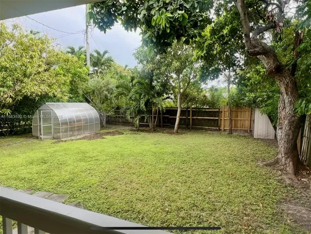 a backyard of a house with lots of green space and fountain