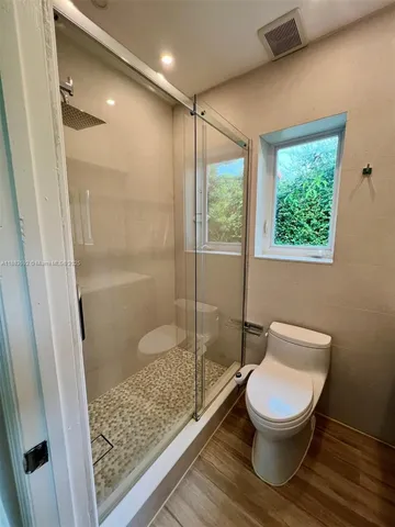 a bathroom with a toilet and a shower