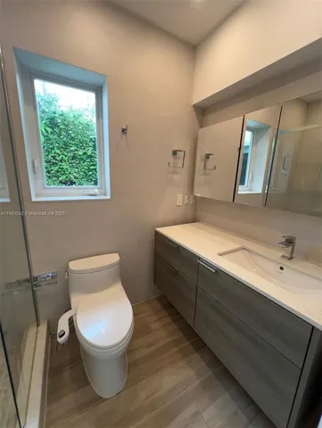 a bathroom with a toilet sink and mirror