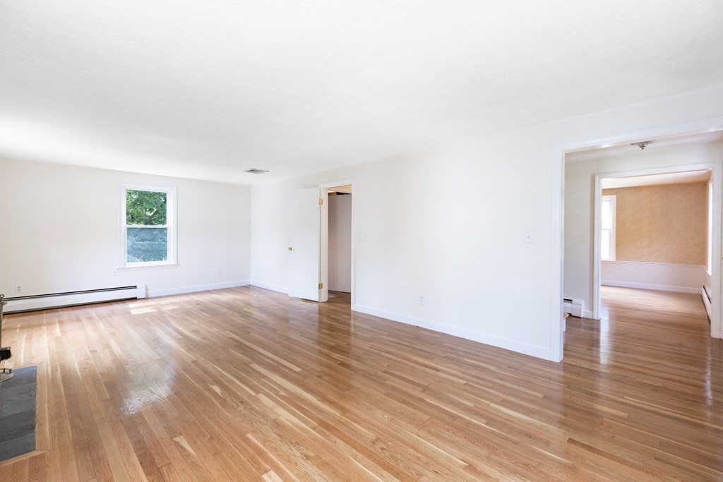 8 Michael Road Wakefield, MA 01880 - Photo 10 of 35 an empty room with wooden floor and windows