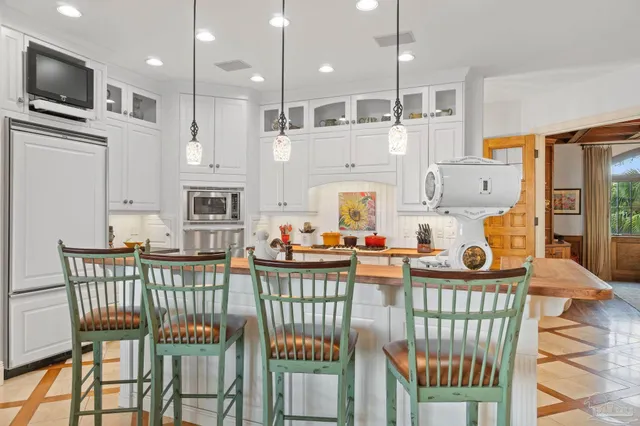 a kitchen with stainless steel appliances kitchen island granite countertop a stove a table and chairs with wooden floor