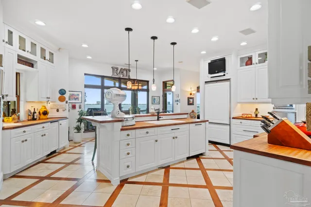 a kitchen with stainless steel appliances kitchen island granite countertop a sink and white cabinets