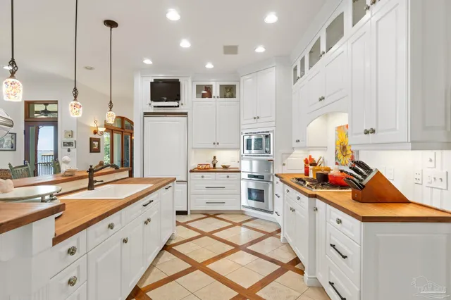 a kitchen with stainless steel appliances kitchen island granite countertop a sink a stove and cabinets
