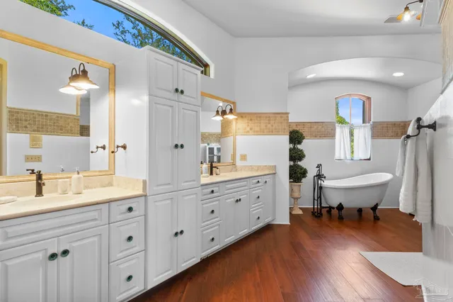 a spacious bathroom with a double vanity sink a mirror a bathtub and a shower