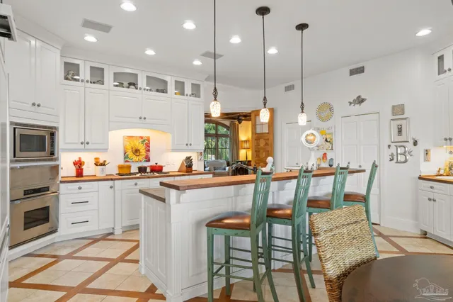 a kitchen with kitchen island granite countertop a table chairs sink and cabinets