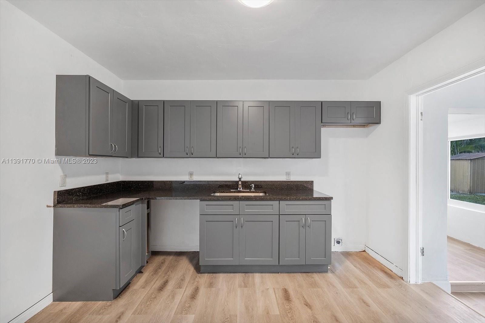 6110 Southwest 20th Street Miami, FL 33155 - Photo 11 of 29 a kitchen with stainless steel appliances granite countertop a sink and wooden cabinets