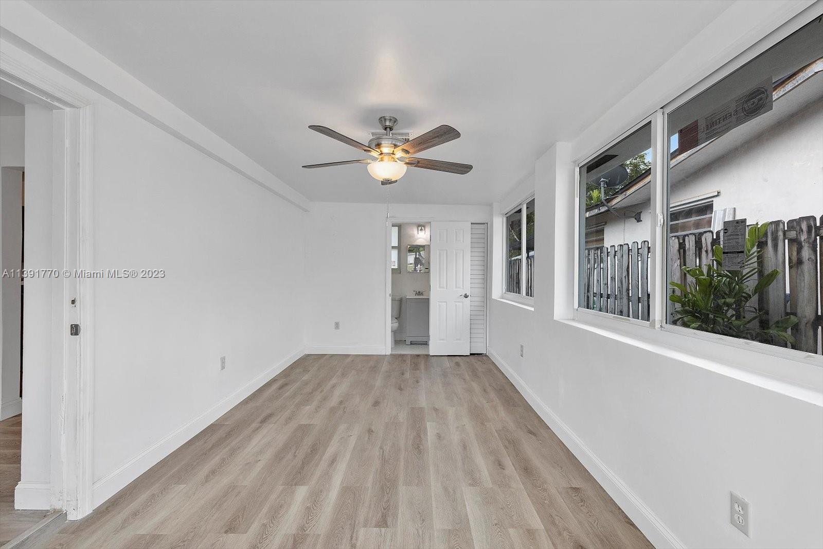 6110 Southwest 20th Street Miami, FL 33155 - Photo 14 of 29 a view of an empty room with a window and wooden floor