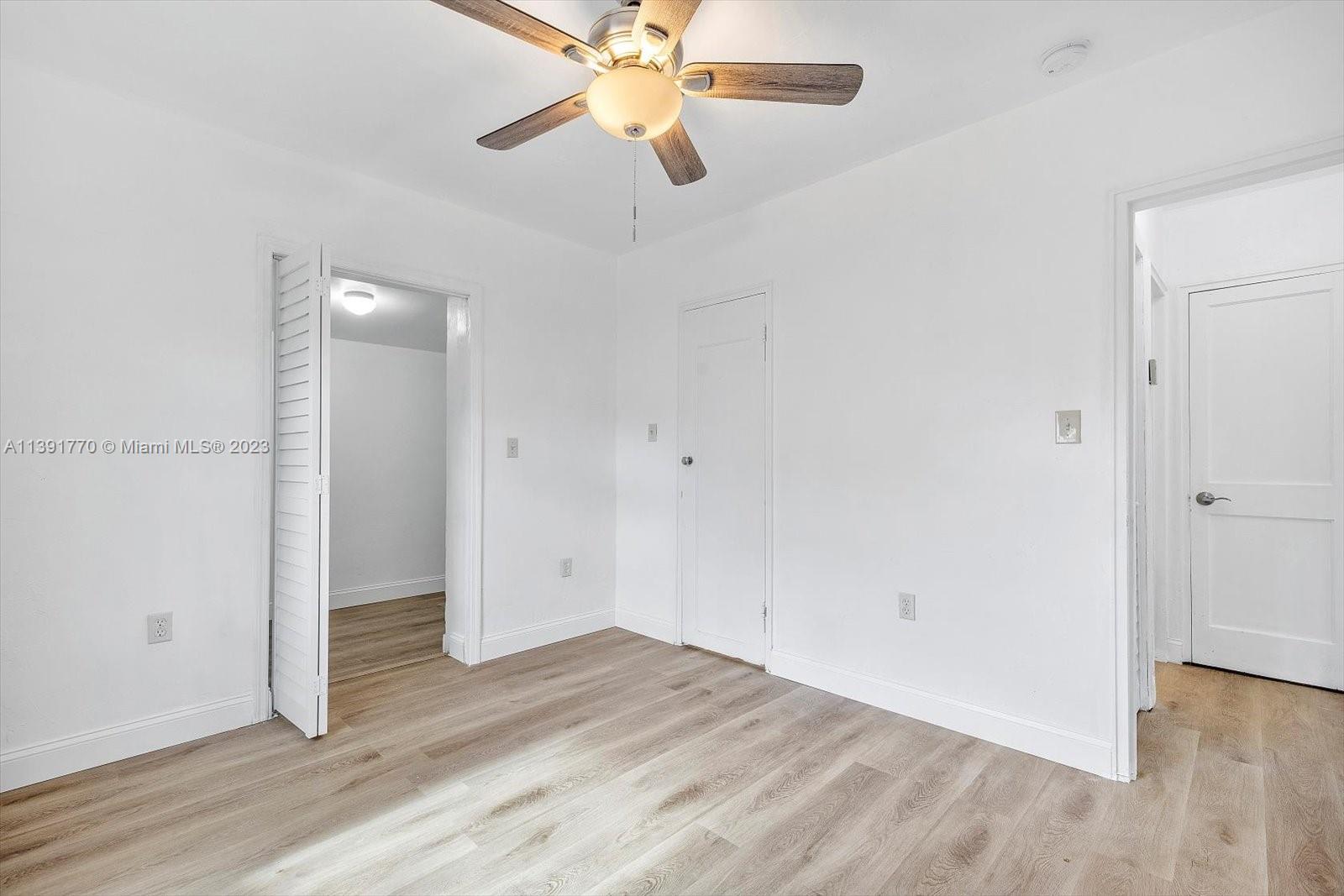 6110 Southwest 20th Street Miami, FL 33155 - Photo 22 of 29 an empty room with wooden floor a ceiling fan and closet area