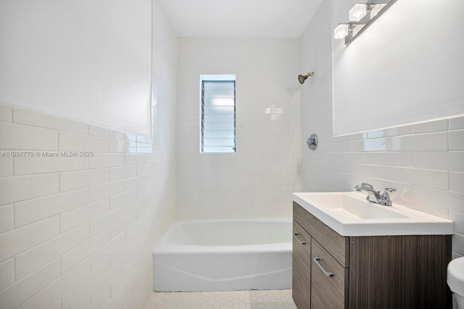 6110 Southwest 20th Street Miami, FL 33155 - Photo 24 of 29 a bathroom with a sink mirror and a bathtub