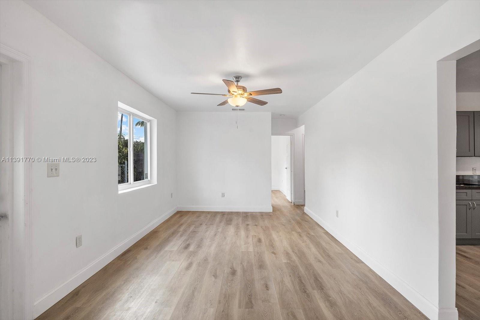 6110 Southwest 20th Street Miami, FL 33155 - Photo 4 of 29 wooden floor in an empty room with a window